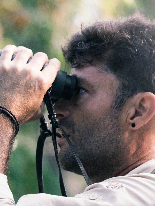 A birder viewing birds with a binocular