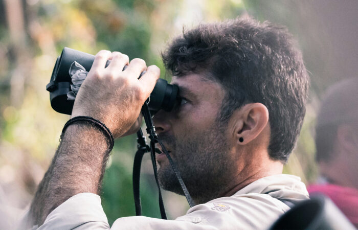 A birder viewing birds with a binocular