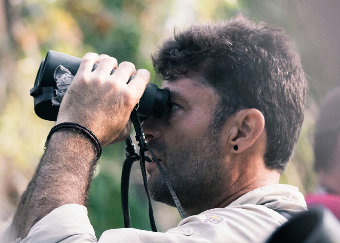 A birder viewing birds with a binocular