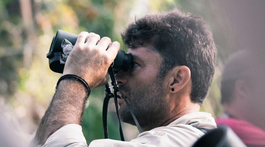 A birder viewing birds with a binocular